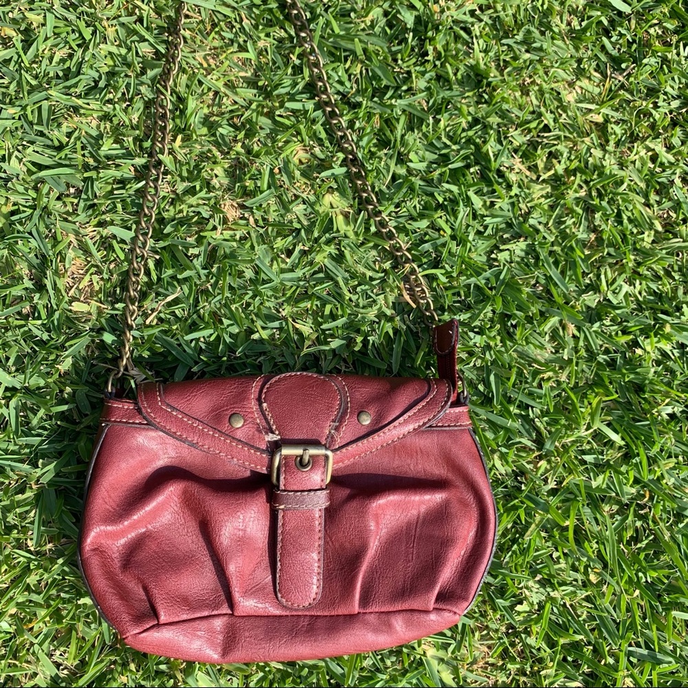 Small rustic red clutch handbag with gold chain.